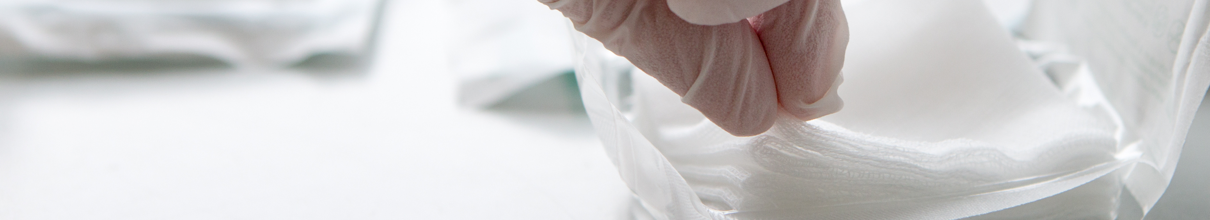 Sterile swabs being removed from packaging with gloves